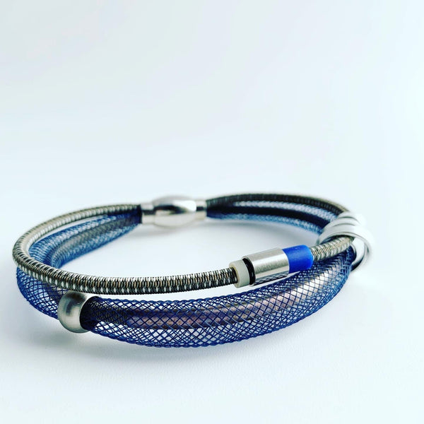This Bracelet has netted tubing with two different kinds of shock cord, aluminum wire, mixed beads and silicon tubing with a magnetic clasp. It is 19cm.