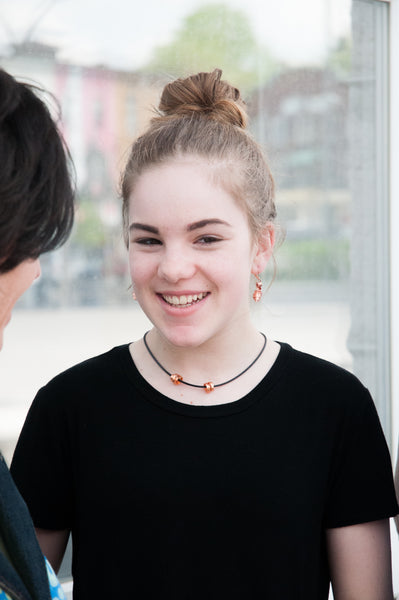 Avery is wearing flat copper Loopt earrings with a thin copper Rubber Loopt.