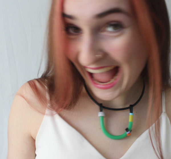 Sadye is wearing the Black with Green, White and Colours Uline on a fine leather cord that hangs 40cm.