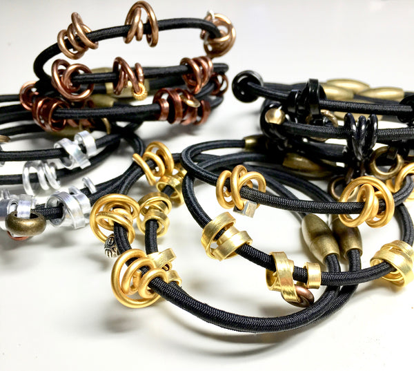 Mix of Loopt bracelets on fine cord in round and thin aluminum wire.