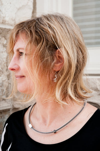 Miranda is wearing Loopt earrings in round silver and a short Tubular