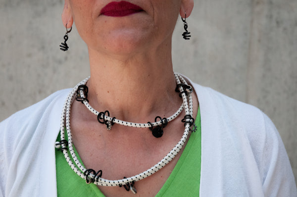 Patricia is wearing Loopt earrings and long Loopt necklace with black round wire.