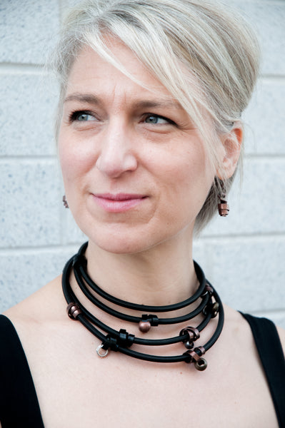 Sandra is wearing Flat Loopt Earrings in bronze with a Heavy loopt necklace/bracelet in bronze and black.