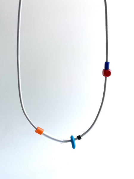 This necklace is made with shock cord silcone and wood beads. It has an interlocking magnetic clasp and hangs 46cm long.