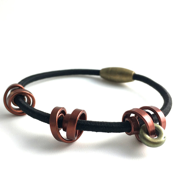 A Loopt bracelet on fine cord in thin bronze coloured aluminum wire.
