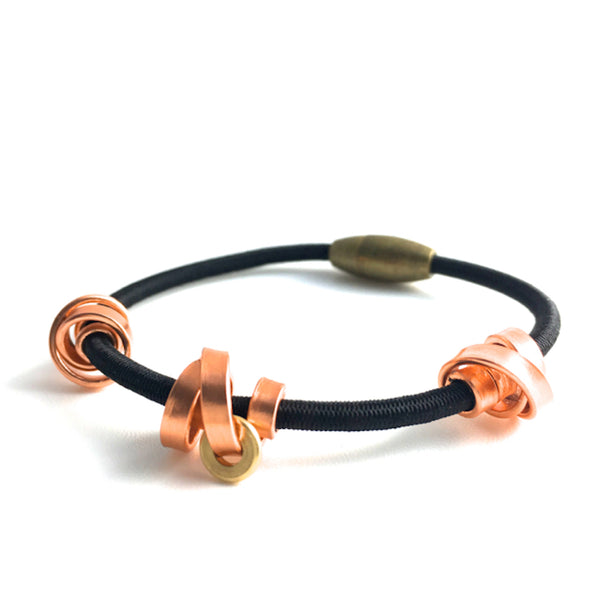 This is a Loopt bracelet on a fine cord and thin copper coloured aluminum wire. All bracelets sport magnetic clasps.