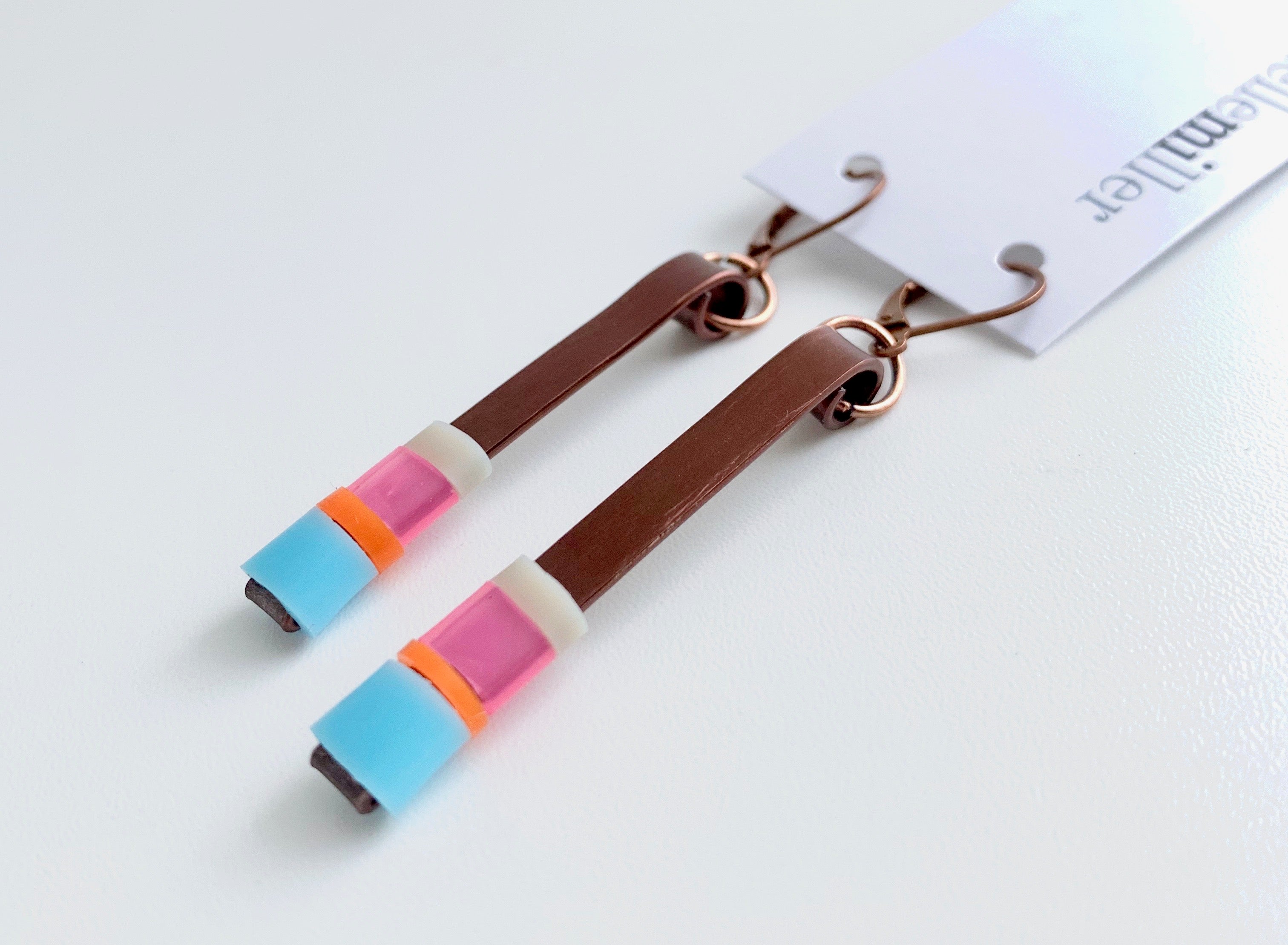 Matchstick earrings in bronze coloured aluminum wire with light blue, pink, beige and orange coloured silicone tubing. These hang 4.5cm in length.