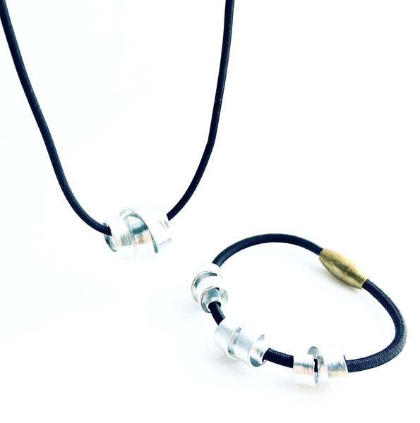 A Rubber Loopt in flat silver and a Loopt bracelet in flat silver on a fine cord.
