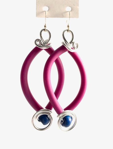 These are made with aluminum wire, silicone tubing and wood beads. They have non nickel fish hooks with rubber stoppers. The hang 7.5cm long and are 3cm wide.