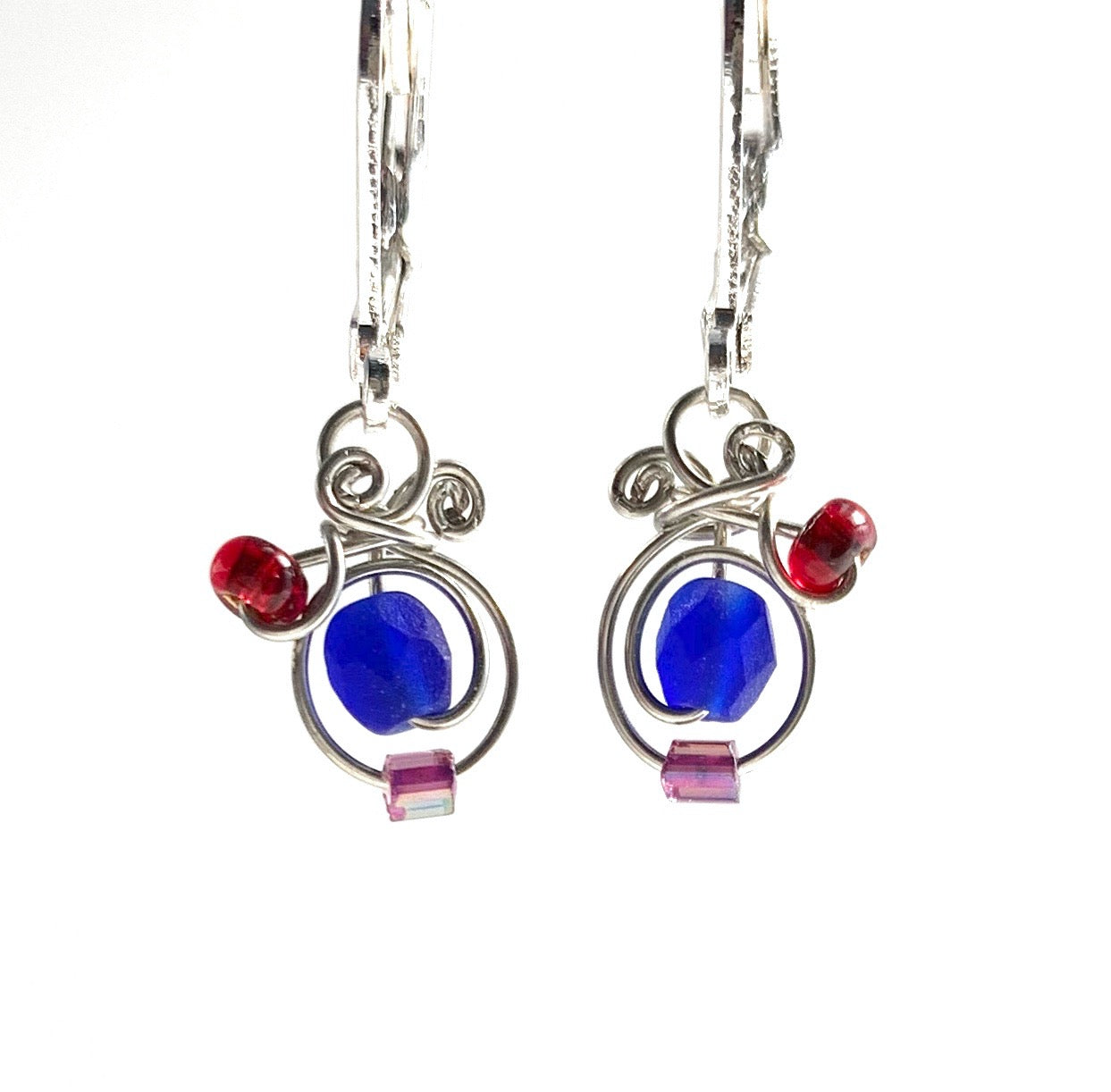 Silver coated copper wire with irridescent royal glass beads with red and purple glass accents. They have leverback hooks and hang a hair past a 1cm long.