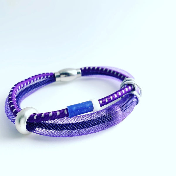 This Bracelet has netted tubing with two different kinds of shock cord, aluminum wire, mixed beads and silicon tubing with a magnetic clasp. It is 20cm. 