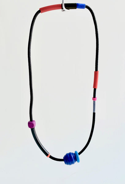 This necklace is made with shock cord silcone and wood and beads. It has an interlocking magnetic clasp and hangs 45.5cm long.