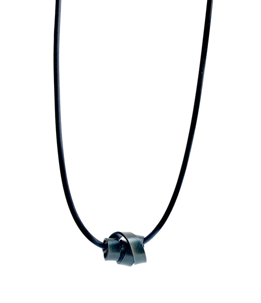 This Rubber Loopt necklace is in flat black coloured aluminum wire. It hangs on a rubber necklace with an interlocking closure. This piece comes in many variations.