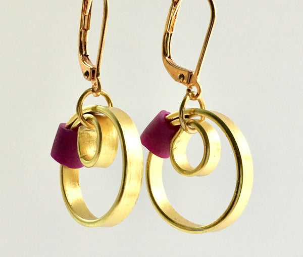 These Reel Earrings are made of gold coloured aluminum wire with added purple silicone beads. All Earrings sport non nickel leverback hooks unless noted otherwise.