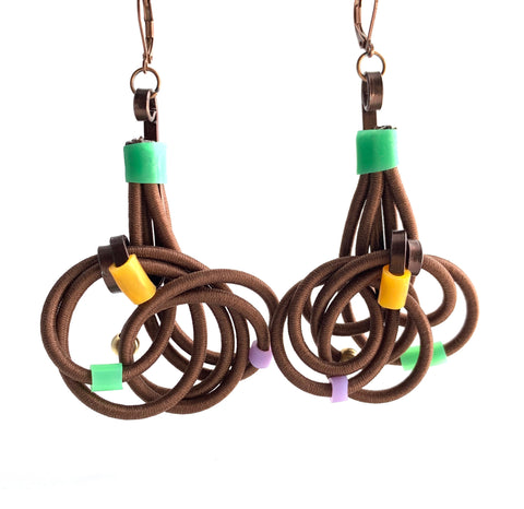 These earrings are made with shock cord bronze coloured aluminum wire, silicone tubing and leverback hooks. They hang 7.5 cm long and are 4.5cm wide.
