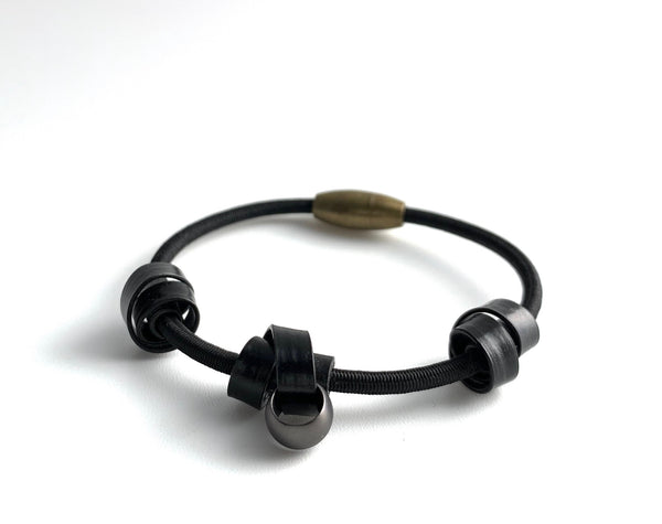 A Loopt bracelet in flat black on a thin cord.