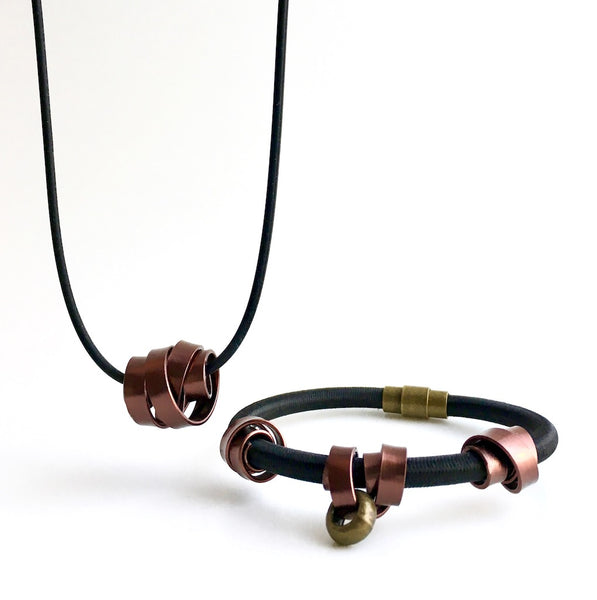 A Rubber Loopt in flat bronze and a Loopt bracelet in flat bronze on a heavy cord.   