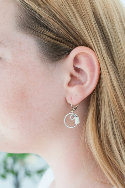 Isabelle is wearing Reel earrings in silver with white