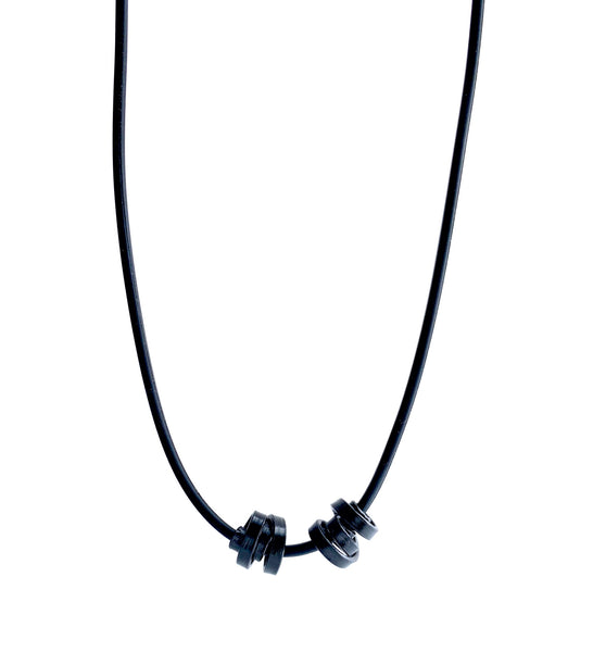 This Rubber Loopt necklace is in thin black. Made of aluminum wire and hangs on a rubber necklace with an interlocking closure. This piece comes in many variations.