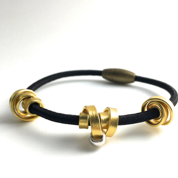 This is a Loopt bracelet on a fine cord and thin gold coloured aluminum wire. All bracelets sport magnetic clasps.